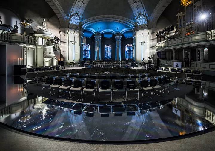 Dunkler Kirchsaal mit schwarzem Boden und blauen Lichtern